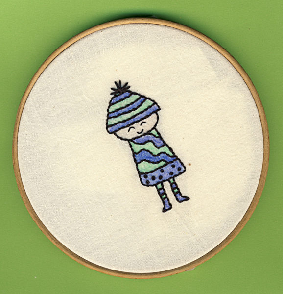 girl bundled up in winter hat and coat - hand embroidery tinted with colored pencils