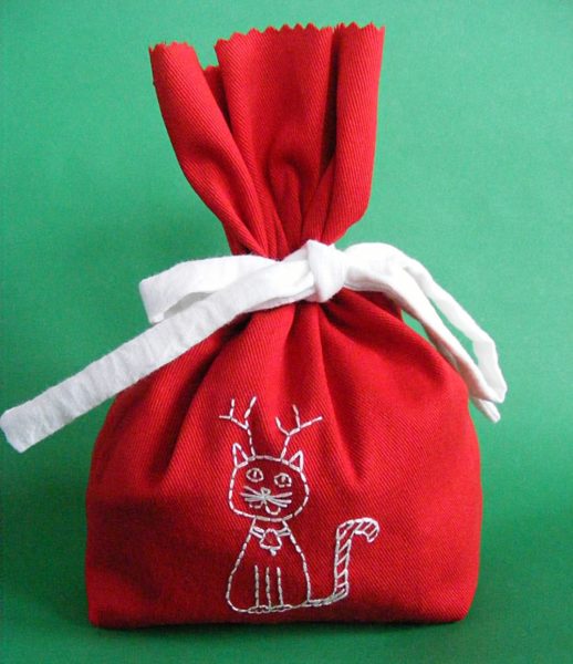 Red Christmas gift bag embroidered with a white cat wearing reindeer antlers