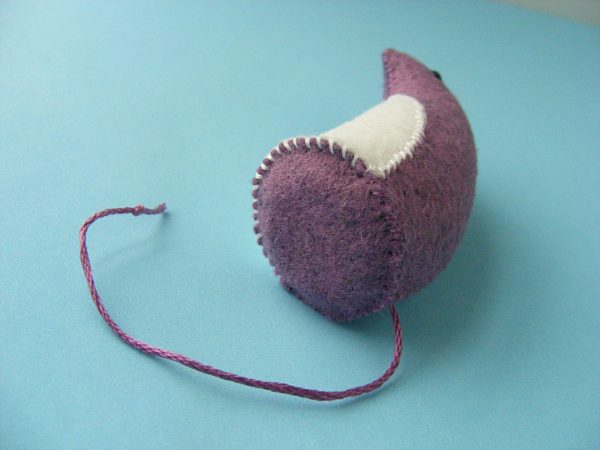 small felt mouse laying on its side so you can see the flat bottom
