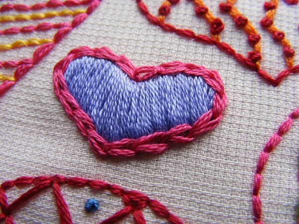 hand embroidered heart showing purple sating stitched heart outlined with chain stitch