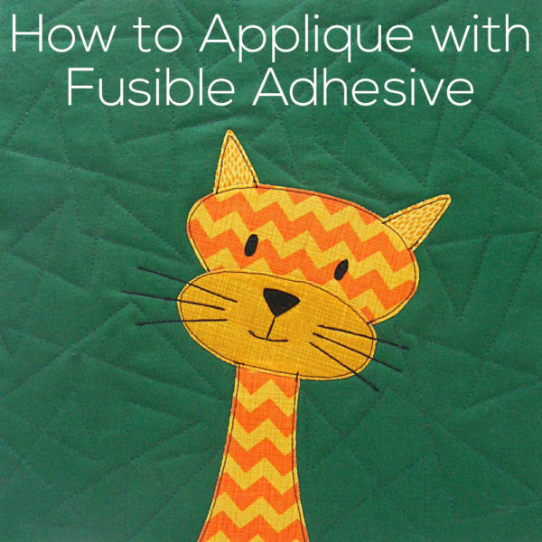 Orange and Yellow applique cat on a green background - title for a blog post showing how to do fusible applique
