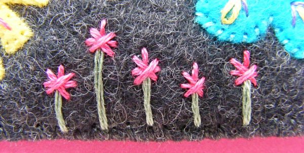 more pink star flowers embroidered on dark grey felt