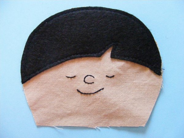 embroidered doll face with felt bangs - partially made with a free doll pattern from Shiny Happy World