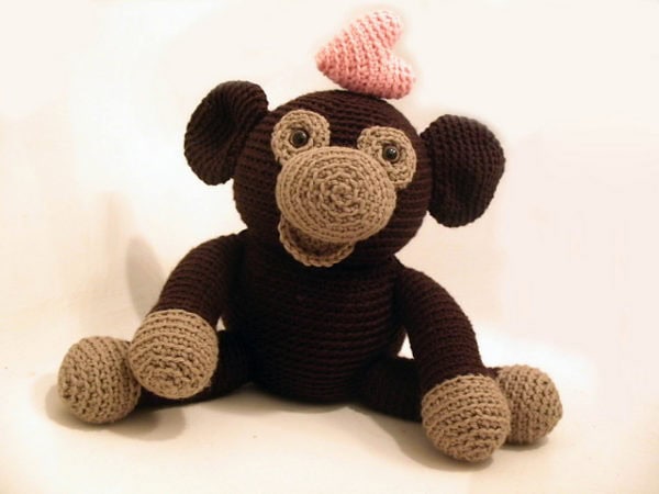 Soft crochet monkey plush toy with pink heart on head, perfect for baby gifts and nursery decor.