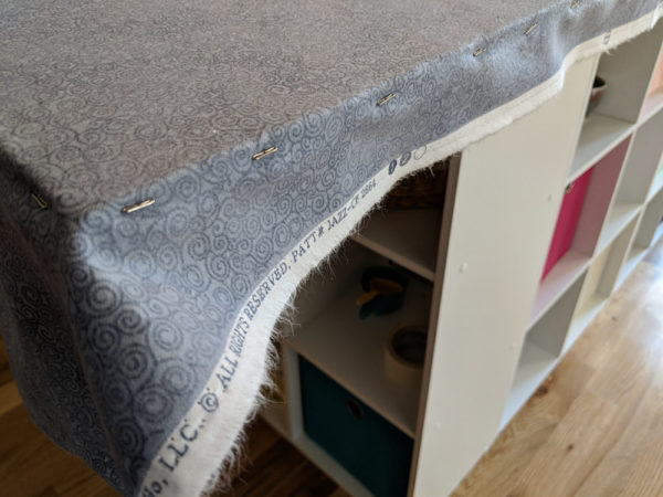 side view of a quilt design wall being made - showing T-pins holding the grey fabric in place