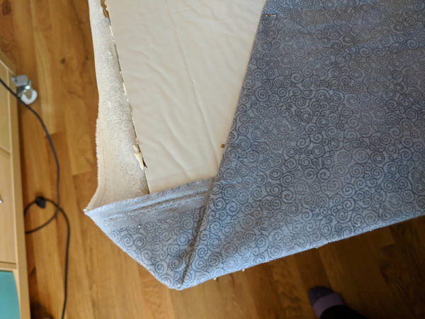 Smoothing the excess fabric on the back of the foam insulation board