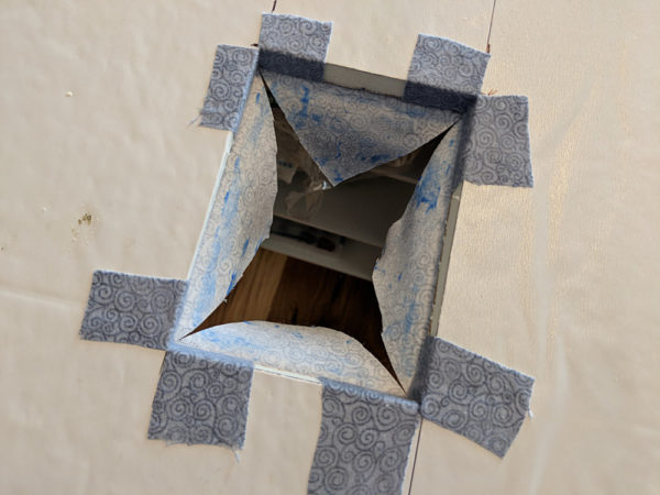 outlet hole with corners covered with grey fabric