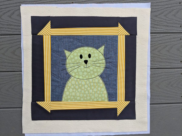 Applique cat with a wonky churn dash frame - all finished except the final trimming and binding