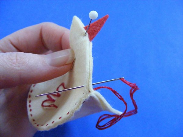 adding the beak to a chicken softie as you sew