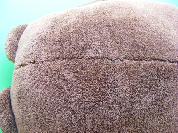 the back side of a stuffed animal showing how invisible the ladder stitch is