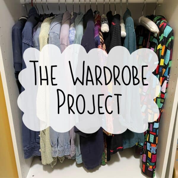 Wardrobe project sign on colorful clothing rack.