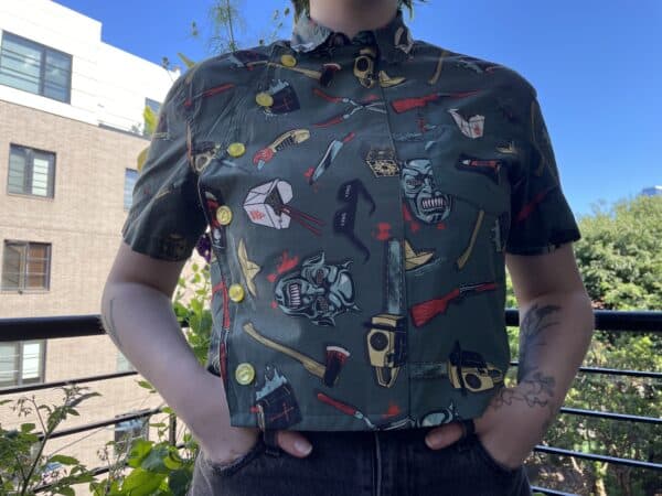 Short-sleeve upcycled button-down shirt with a colorful, playful tool and weapon print.