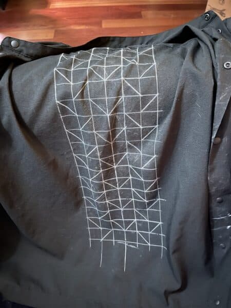 Drawing of a smocking pattern on black fabric for smocked shirt project.